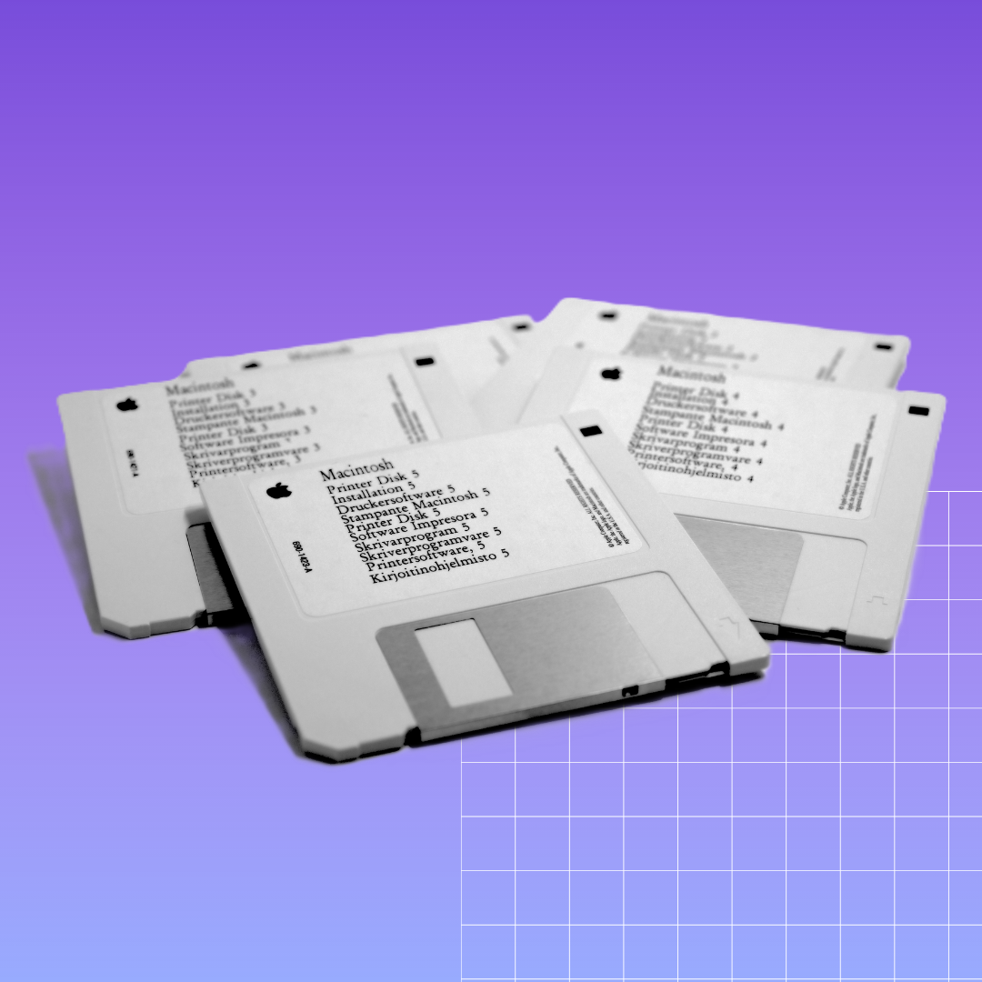 A pile of identical white floppy disks grouped together. They are isolated in a cool purple-blue background.